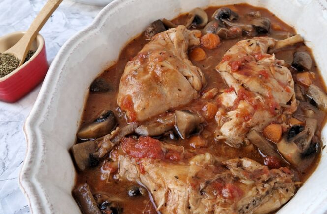 Coelho estufado com puré de batata cremoso servido com molho de tomate, cenoura e cogumelos